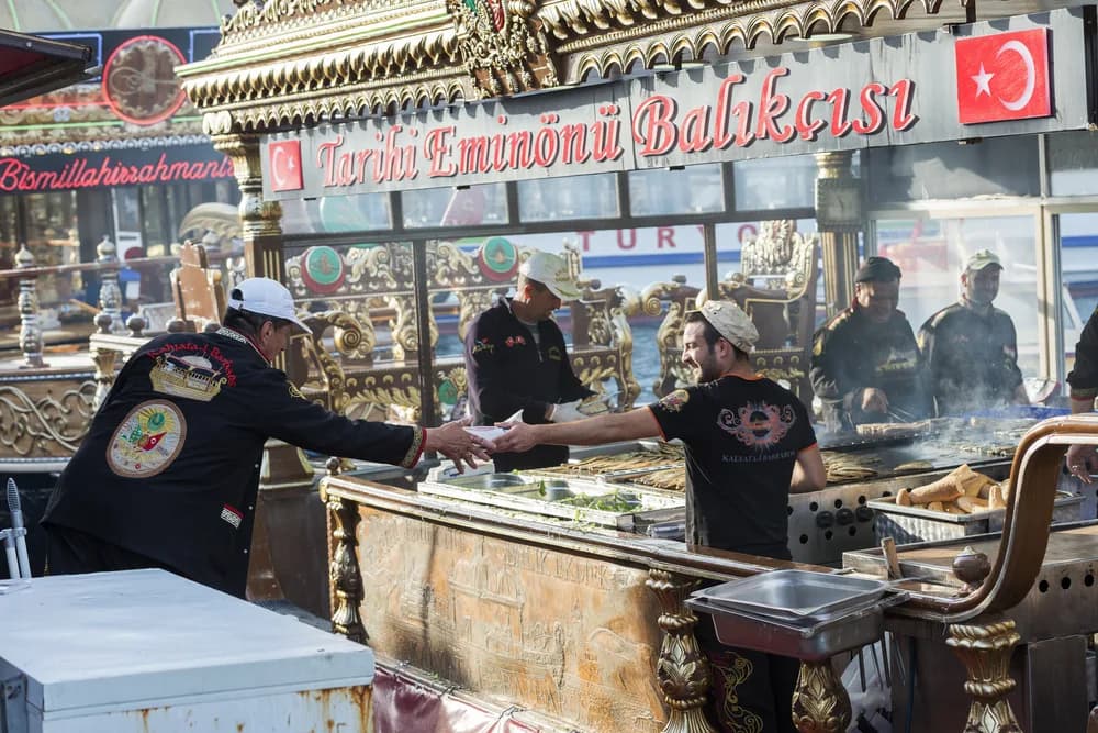 Vendors serving fish sandwiches at a historic Eminönü fish sandwich stall, Istanbul