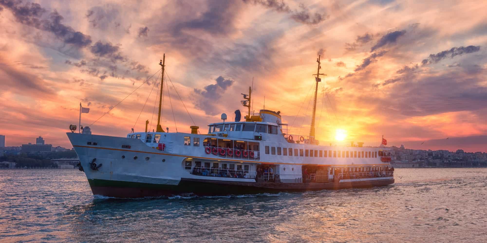 a large boat on water with a sunset in the background